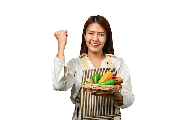 Mujer asiática bonita sosteniendo una canasta con verduras aisladas en el fondo Concepto de comida saludable