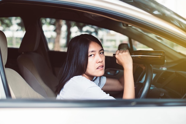Mujer asiática borracha bebiendo alcohol mientras conduce un automóvil en la carretera Las mujeres conducen su automóvil con una botella de cerveza Concepto de conducción peligroso