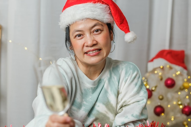 Mujer asiática brindando con champán celebrar el año nuevo y la fiesta de Navidad videollamada a amigos en casa