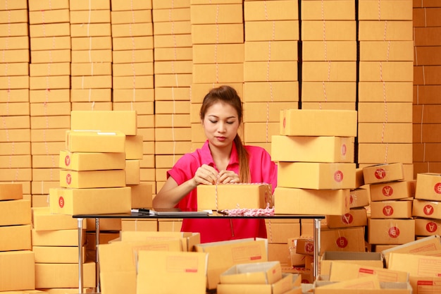 Mujer asiática cajas de embalaje en casa en el negocio de compras en línea de comercio electrónico