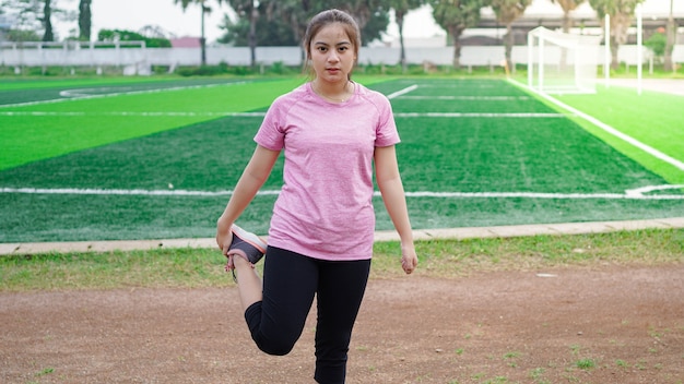 Mujer asiática calentando antes de correr