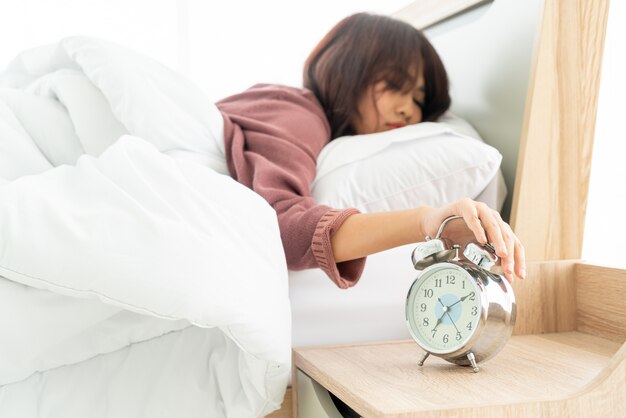 Mujer asiática en la cama y despertarse por la mañana