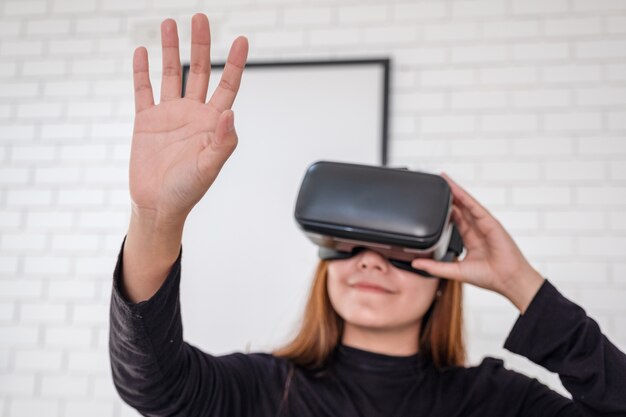 Una mujer asiática con cámara VR mientras disfruta jugando juegos