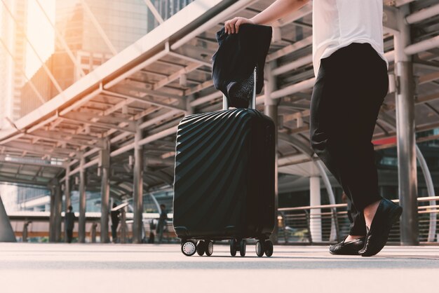 Mujer asiática caminando a la terminal del aeropuerto con equipaje