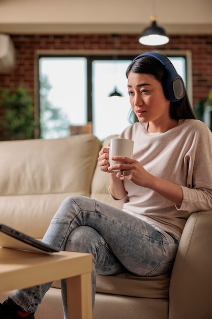 Mujer asiática en casa viendo una plataforma de suscripción de transmisión de películas en línea, series de películas de entretenimiento tecnología web de Internet que transmite una nueva aplicación digital de medios en una computadora portátil