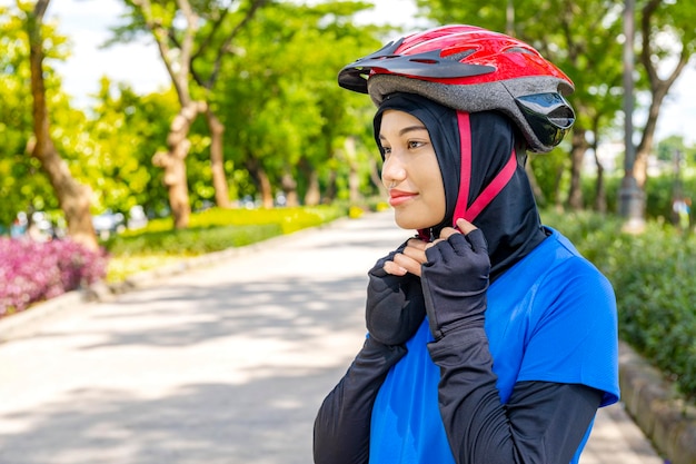 Mujer asiática con casco preparándose para el paseo en bicicleta