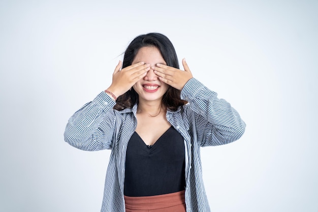 Mujer asiática cerrando los ojos con ambas palmas en un fondo aislado
