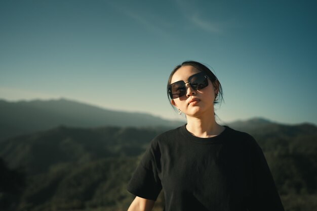 Mujer asiática con cielo azul y montaña