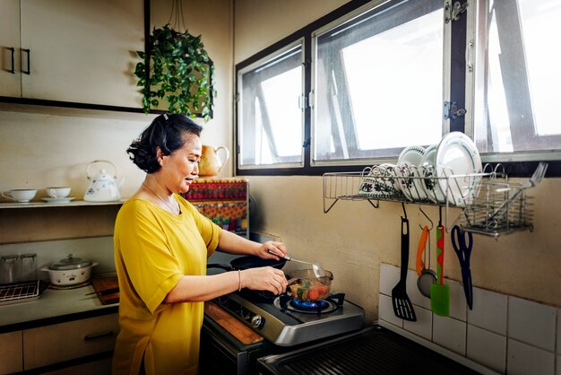 Foto mujer asiática está cocinando en la cocina