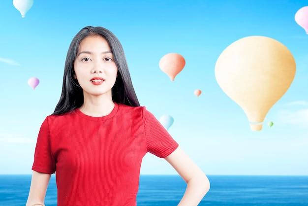 Mujer asiática con coloridos globos de aire volando con fondo de cielo azul