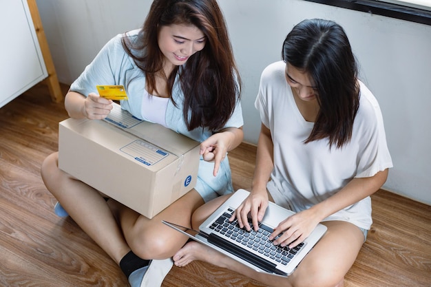 Mujer asiática comprando en una laptop en su casa