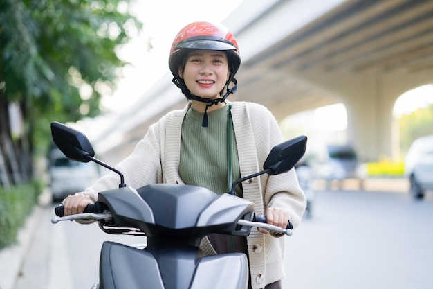 Mujer asiática conduciendo una moto de camino al trabajo