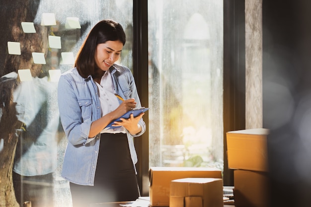 Mujer asiática consultar productos en stock con intención y felices.