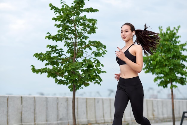 Mujer asiática corriendo en el paseo marítimo Trotar por la mañana El atleta entrena