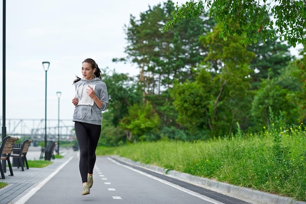 Foto mujer asiática corriendo en el paseo marítimo trotar por la mañana el atleta entrena