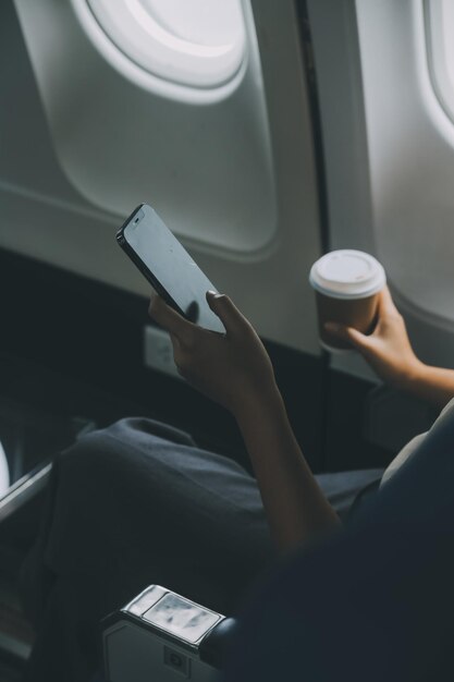 Foto mujer asiática disfrutando disfruta de un café vuelo cómodo mientras está sentado en la cabina del avión pasajeros cerca de la ventana