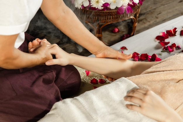 Mujer asiática disfrutando de un masaje exfoliante con sal en el spa Spa de salud y masaje concepto tailandés Chica recibiendo tratamiento de masaje holístico mujer masajista tailandesa recibiendo masaje