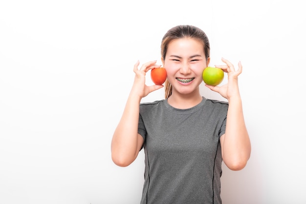 Mujer asiática divirtiéndose con manzana verde y tomate