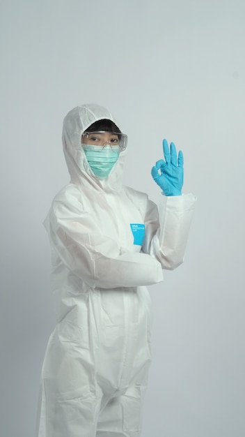 La mujer asiática del doctor usa traje PPE o equipo de protección personal y máscara y guantes médicos