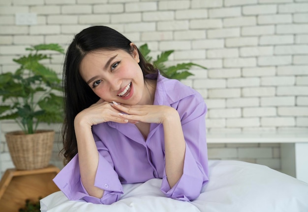 Foto mujer asiática en el dormitorio