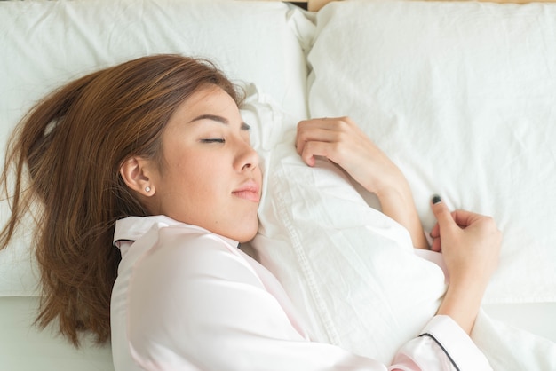 mujer asiática durmiendo en la cama
