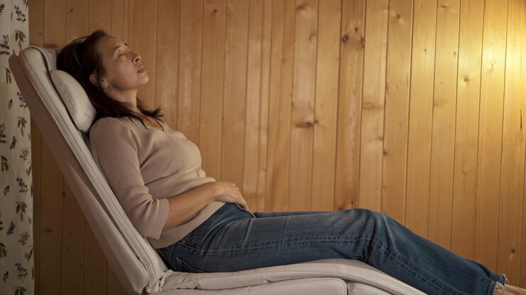 Mujer asiática durmiendo en el perfil del sillón filmada dentro de una casa