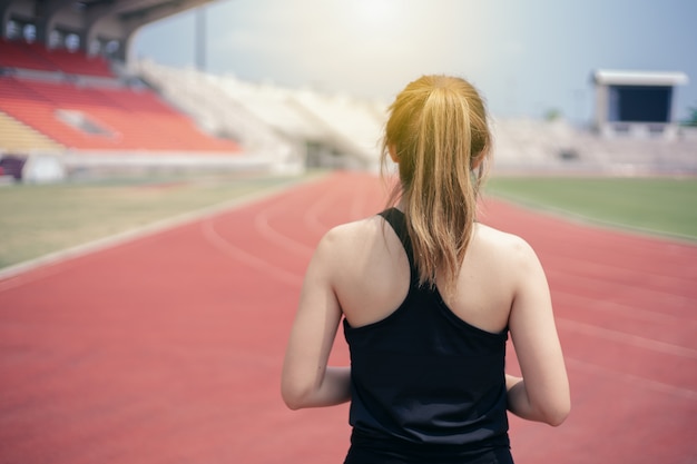 Mujer asiática con el ejercicio de la ropa del deporte al aire libre.