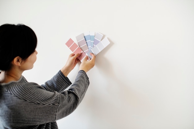 Mujer asiática eligiendo el color de la pared