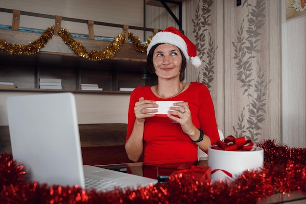 Mujer asiática emocionada sosteniendo y abriendo regalo de Navidad