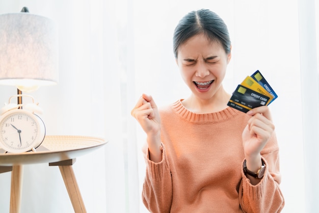 Mujer asiática emocionada con una tarjeta de crédito