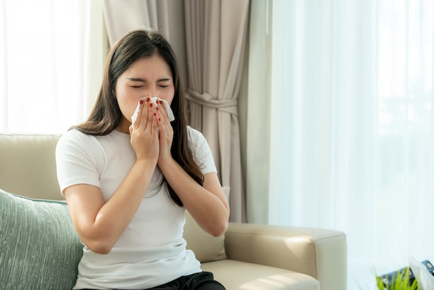 Mujer asiática enferma y triste con estornudos