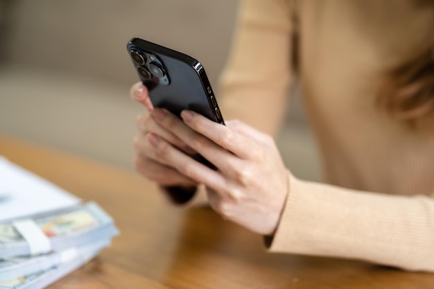 Mujer asiática enviando mensajes de texto revisando las redes sociales sosteniendo un teléfono inteligente en casa Conversación con novio o amigo