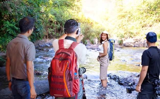 Mujer asiática y equipo de filmación en la cascada