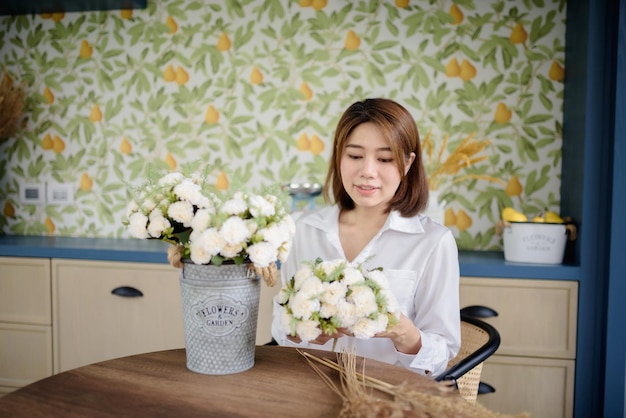 Una mujer asiática está arreglando flores.