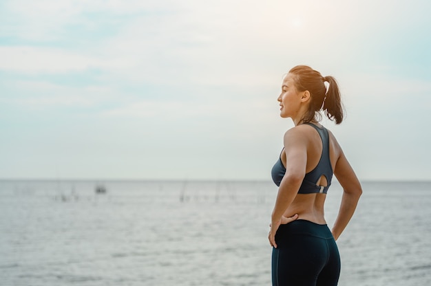 Mujer asiática está parado para respirar aire natural en la playa.