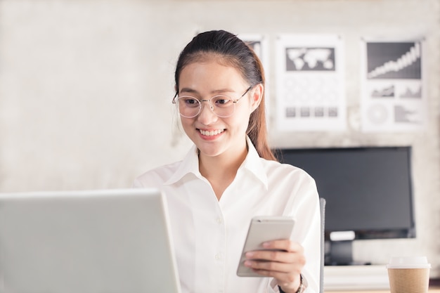 , Mujer asiática están felizmente trabajando en la oficina