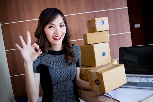 La mujer asiática feliz y alegre hace compras en línea o vende productos