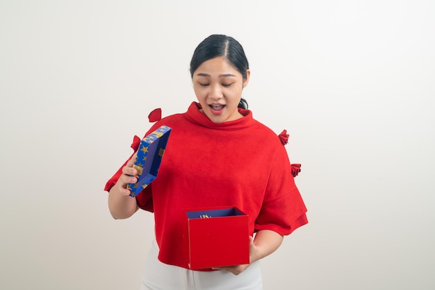 Mujer asiática feliz con camisa roja con caja de regalo a mano para el festival de Navidad