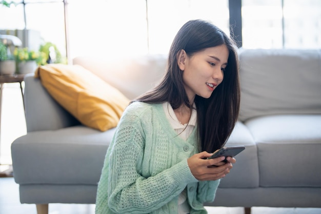 Mujer asiática feliz haciendo una lista de comprobación para empacar la maleta antes del viaje de vacaciones