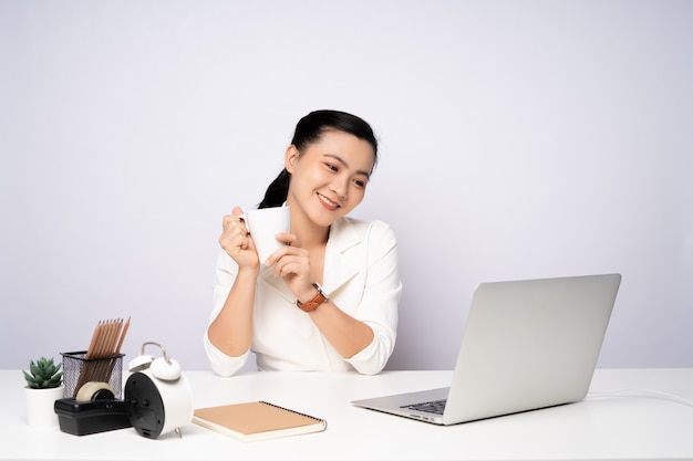 Mujer asiática feliz sonriendo tomar un descanso después de trabajar en una computadora portátil. aislado sobre fondo blanco.