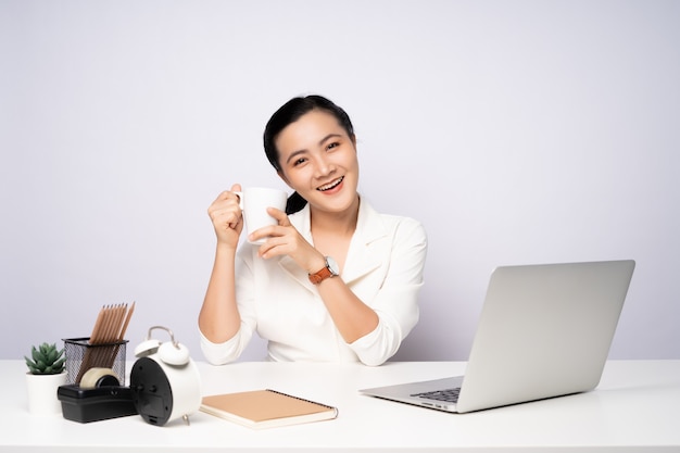 Mujer asiática feliz sonriendo tomar un descanso después de trabajar en una computadora portátil. aislado sobre fondo blanco.