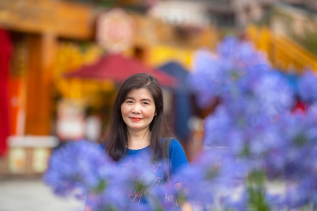 Foto mujer asiática con flor morada