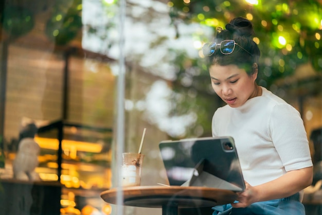 Mujer asiática freelance digital nómada carrera felicidad trabajo alegre sonriente trabajando en línea con dispositivo inteligente tableta teléfono inteligente ocupación en el extranjero proyecto trabajo en cualquier lugar nuevo estilo de vida sin marco