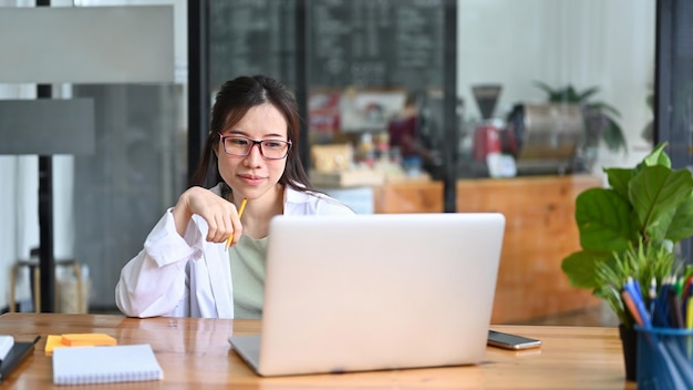 Mujer asiática freelance trabajando con computadora portátil en el café