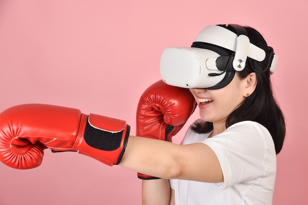 Mujer asiática golpeando un puñetazo con gafas vr Trabajando con la aplicación de videojuegos de boxeo de auriculares de realidad virtual Mujer joven disfruta de una nueva experiencia de fitness con tecnología vr Foto de estudio