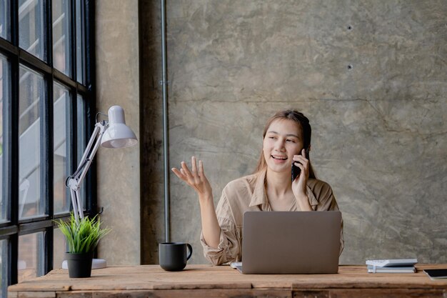 Mujer asiática hablando por teléfono, es vendedora en una empresa nueva, llama a los clientes para vender productos y promociones Concepto de venta de productos a través de canales telefónicos