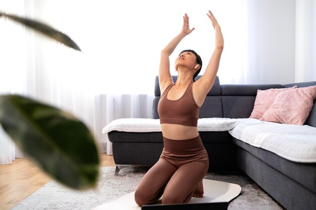 Mujer asiática haciendo ejercicio de yoga en casa