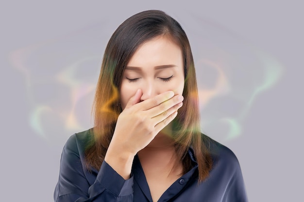 Mujer asiática haciendo una prueba de aliento a mano por la noche Mujer asiática vestida de azul tiene mal aliento Halitosis