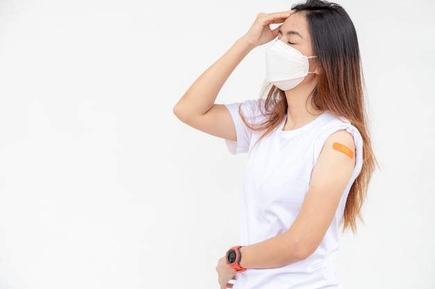 Foto mujer asiática hermosa joven que tiene dolor de cabeza doloroso. efecto después de recibir la vacuna con espacio de copia.