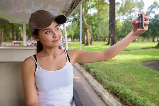 Foto mujer asiática hermosa joven turista tomando selfie con teléfono